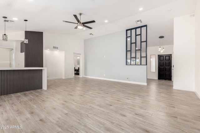 unfurnished living room with a ceiling fan, visible vents, light wood-style flooring, and vaulted ceiling