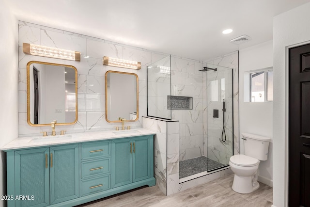 bathroom featuring visible vents, a sink, a marble finish shower, and toilet