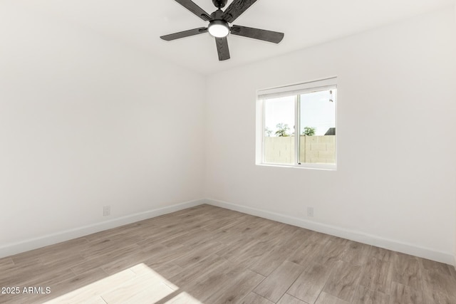empty room featuring baseboards, ceiling fan, and light wood-style flooring