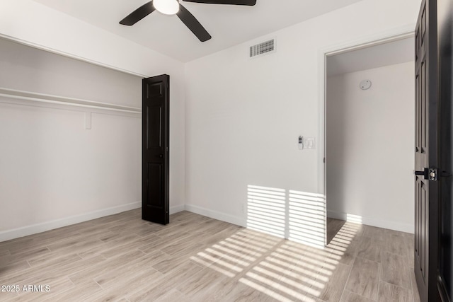 unfurnished bedroom with ceiling fan, baseboards, light wood-type flooring, visible vents, and a closet
