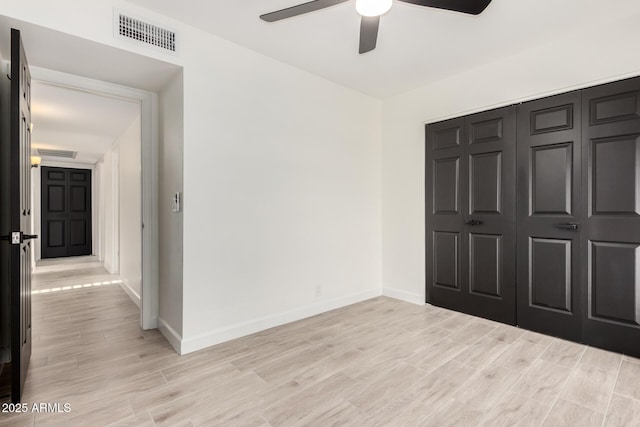 unfurnished bedroom with baseboards, visible vents, and light wood finished floors