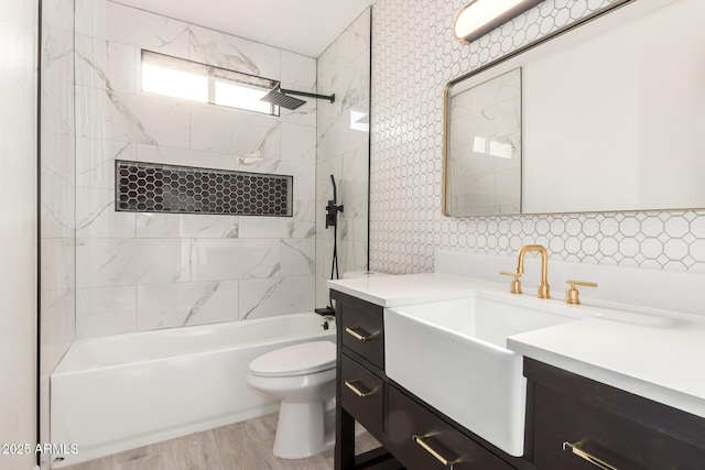 full bath with toilet, bathtub / shower combination, wood finished floors, and vanity