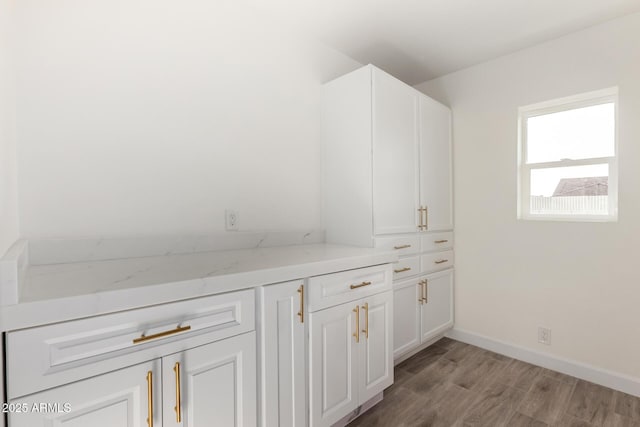 interior space featuring baseboards and light wood finished floors