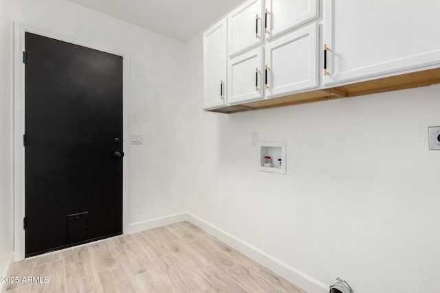 washroom with baseboards, wood finish floors, washer hookup, and cabinet space