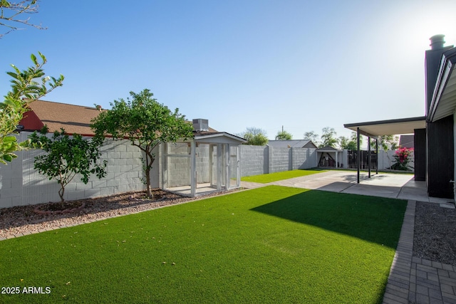 view of yard featuring a patio, a fenced backyard, a shed, and an outdoor structure