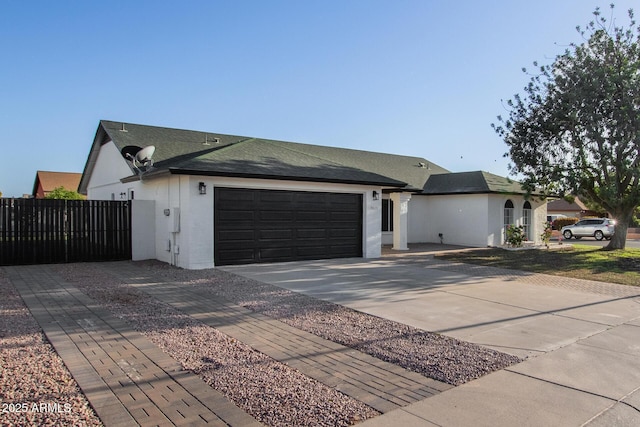 single story home featuring driveway, roof with shingles, fence, an attached garage, and stucco siding