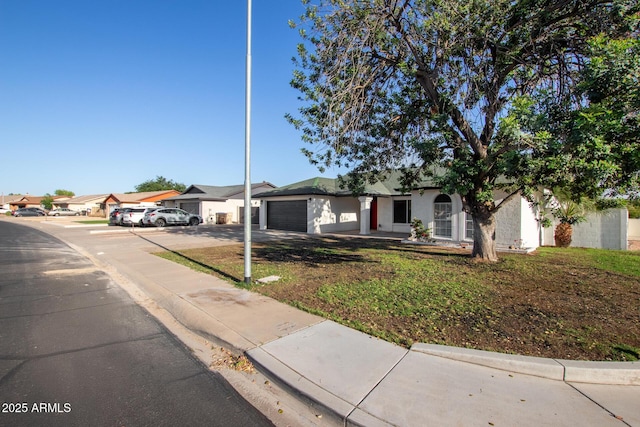 ranch-style house with an attached garage, driveway, and a front yard