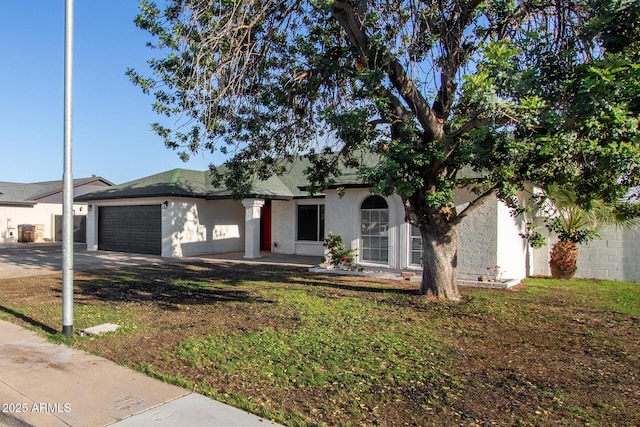 single story home with stucco siding, driveway, a front yard, and a garage