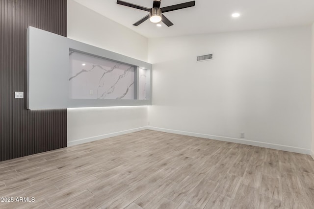 spare room with visible vents, wood finished floors, lofted ceiling, baseboards, and ceiling fan