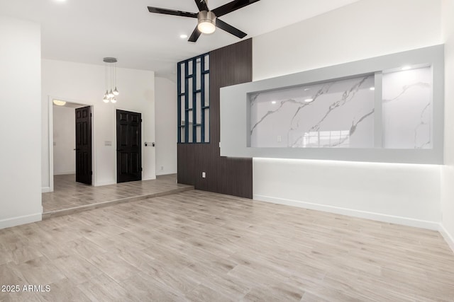 unfurnished living room featuring baseboards, a ceiling fan, wood finished floors, and recessed lighting