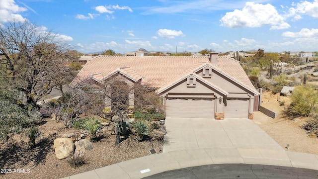 view of front of property featuring driveway, an attached garage, a tile roof, and stucco siding