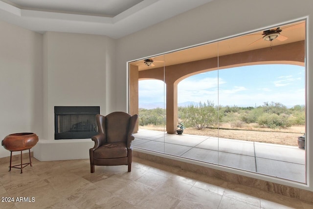 living area featuring light tile flooring and ceiling fan