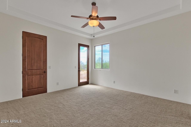 unfurnished room with ceiling fan, carpet, and a raised ceiling