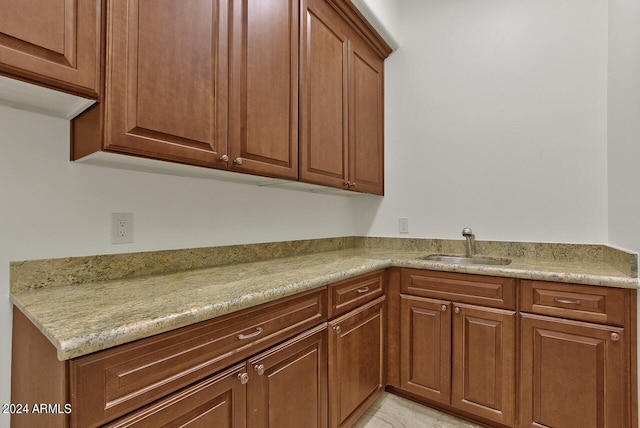 kitchen featuring light stone countertops and sink