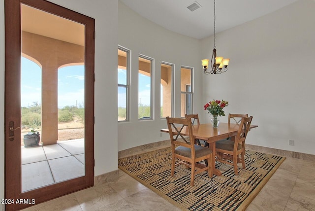 tiled dining room featuring a chandelier