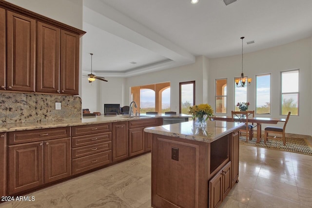 kitchen with light stone countertops, ceiling fan with notable chandelier, a healthy amount of sunlight, and light tile floors