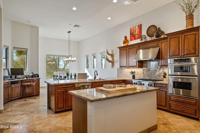 kitchen with wall chimney exhaust hood, a wealth of natural light, a center island, and kitchen peninsula