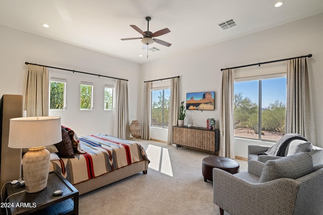 bedroom featuring multiple windows, ceiling fan, and light colored carpet