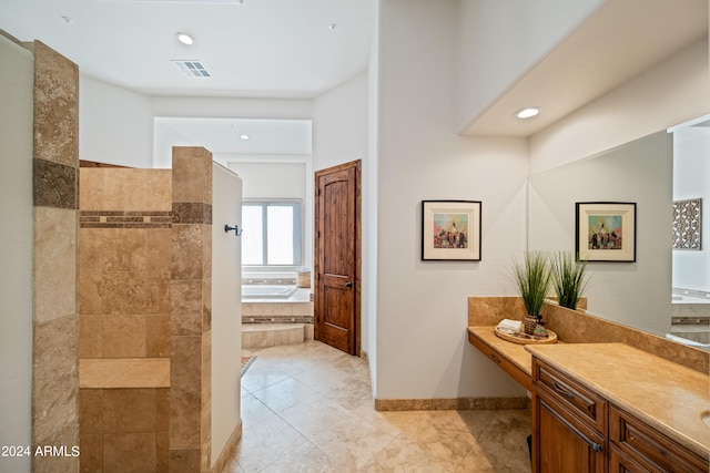 bathroom featuring tile patterned floors, tiled bath, and vanity