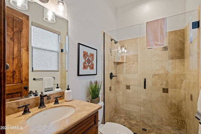 bathroom with a shower with shower door, vanity, and toilet