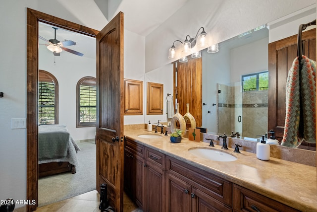 bathroom with tile patterned flooring, ceiling fan, walk in shower, and vanity