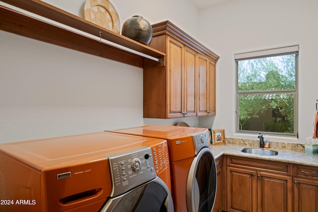 washroom featuring cabinets, sink, and washing machine and clothes dryer