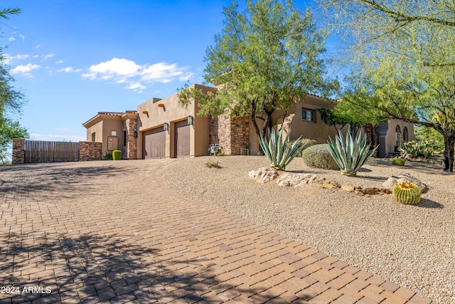 pueblo revival-style home featuring a garage