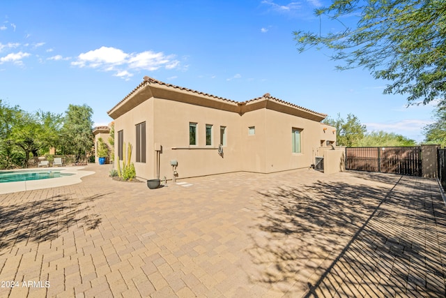 rear view of house with a patio and a fenced in pool