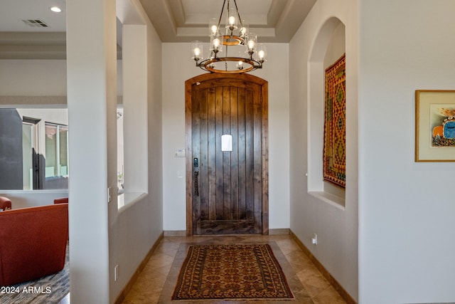 foyer with a chandelier and a tray ceiling