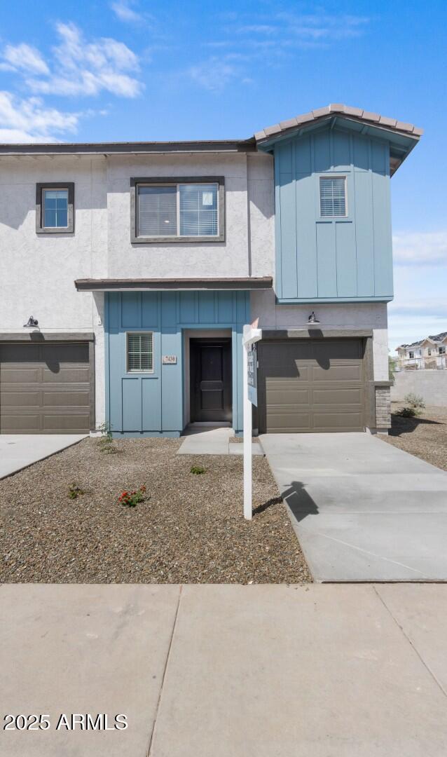 view of front of property featuring board and batten siding, driveway, and a garage