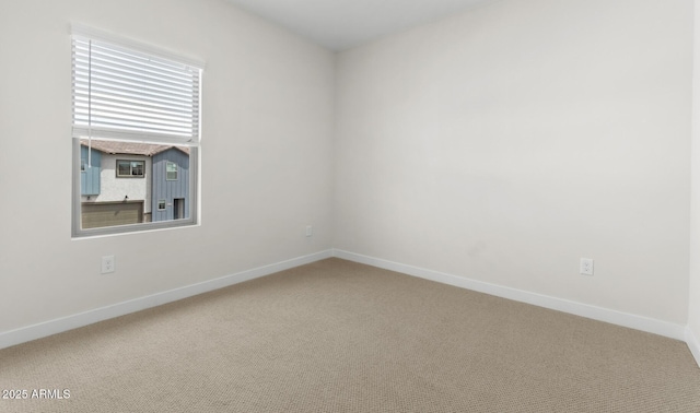spare room featuring baseboards and carpet floors