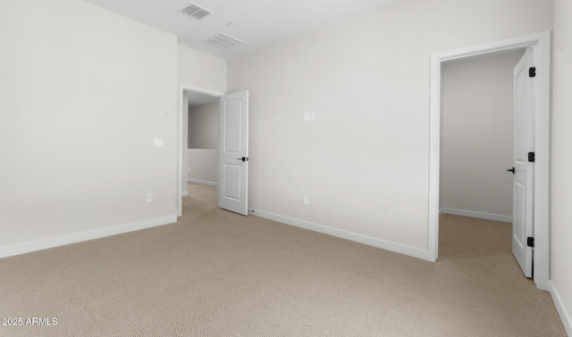 unfurnished bedroom with light colored carpet, baseboards, and visible vents