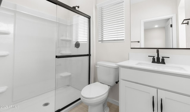 bathroom featuring a stall shower, vanity, and toilet
