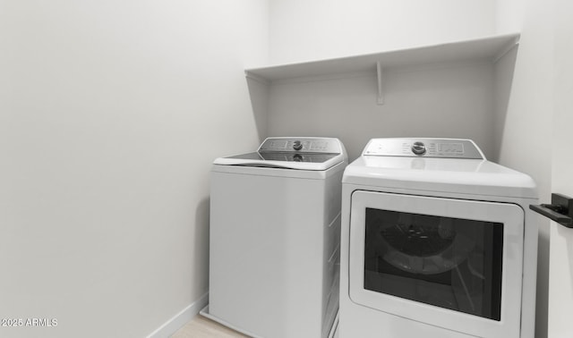 laundry area with laundry area, independent washer and dryer, and baseboards