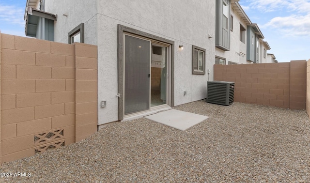 back of property featuring fence, stucco siding, and cooling unit