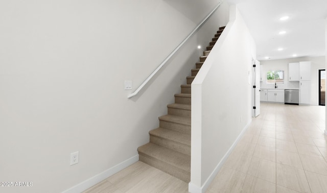 stairway featuring baseboards and recessed lighting