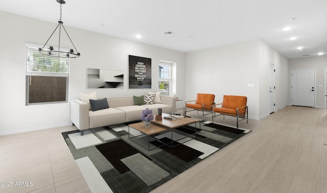 living area with a notable chandelier, baseboards, visible vents, and recessed lighting