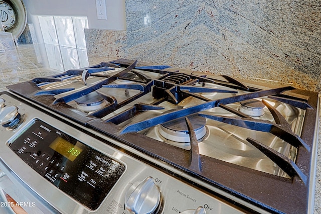 interior details featuring stainless steel range with gas stovetop and decorative backsplash