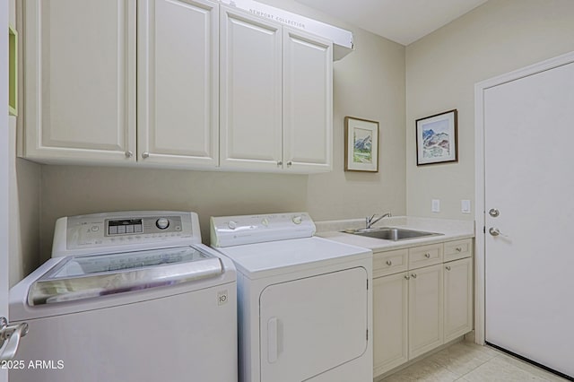 washroom featuring washer and dryer, cabinet space, light tile patterned floors, and a sink