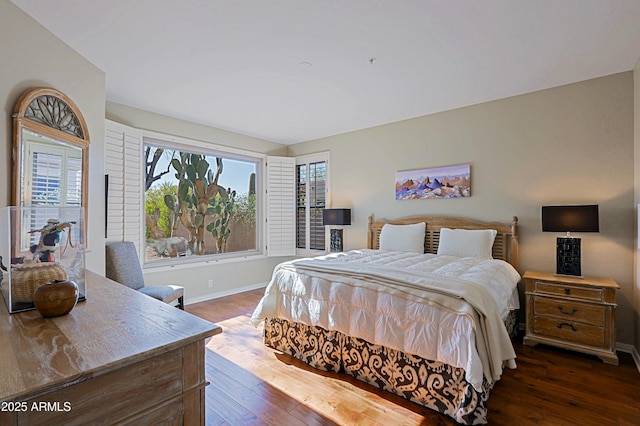 bedroom with dark wood-type flooring and baseboards