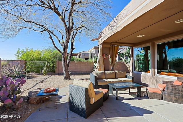 view of patio / terrace with an outdoor living space with a fire pit and a fenced backyard