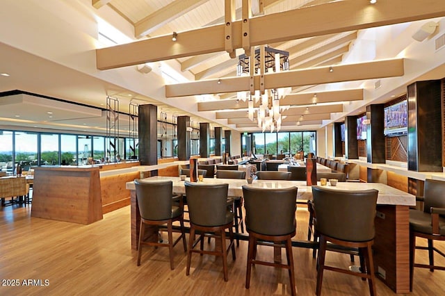 dining room with visible vents, vaulted ceiling with beams, and wood finished floors