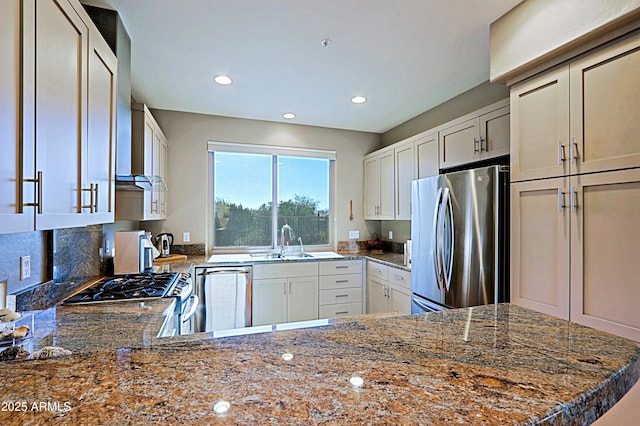 kitchen featuring stone countertops, a sink, white cabinetry, recessed lighting, and stainless steel appliances