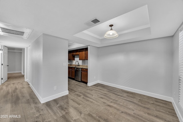 kitchen featuring dishwasher, a tray ceiling, and visible vents