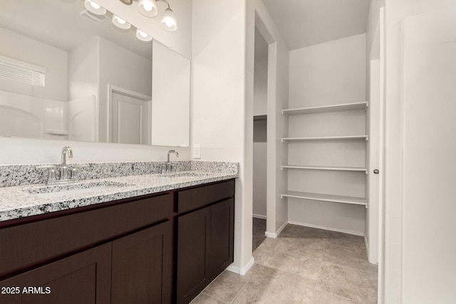 5240 E Gummite Dr, San Tan Valley, AZ 85143 - full bathroom with double vanity, a walk in closet, and baseboards