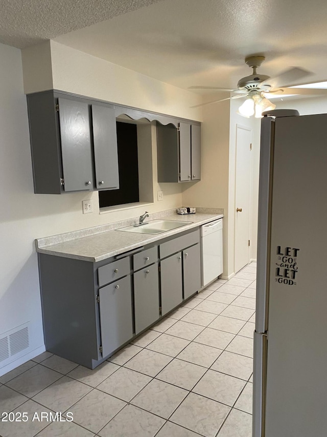 kitchen with gray cabinets, white appliances, a ceiling fan, and a sink