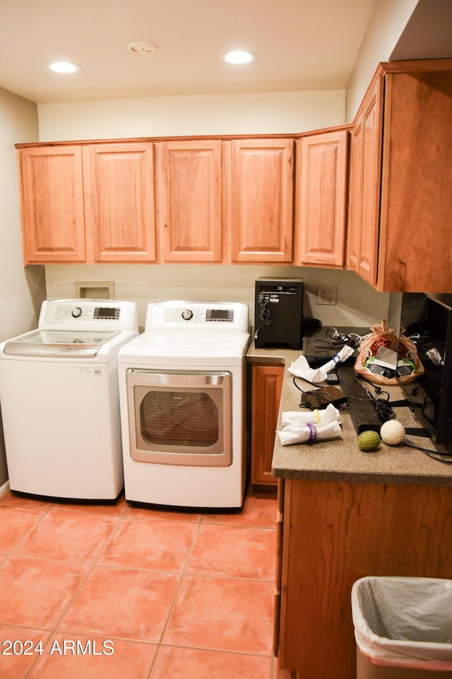 laundry room with cabinets, light tile patterned floors, and washing machine and clothes dryer