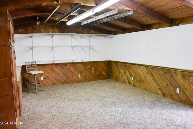 basement with carpet floors, wooden walls, and wooden ceiling