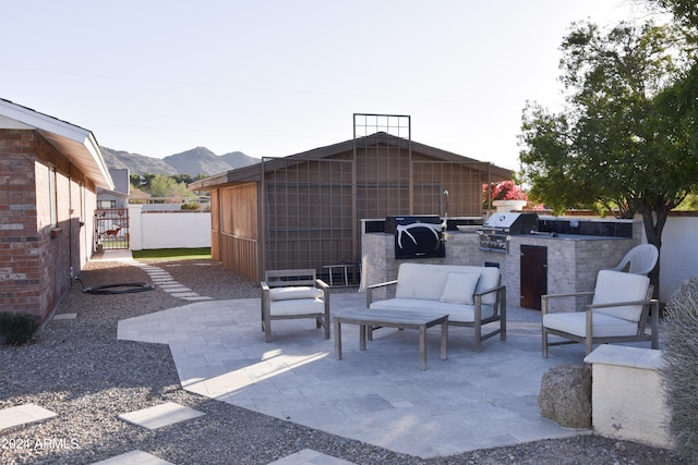 view of patio / terrace featuring an outdoor kitchen, a mountain view, and grilling area