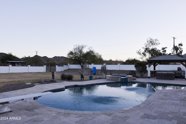 view of pool featuring an in ground hot tub, a gazebo, a patio area, and a mountain view